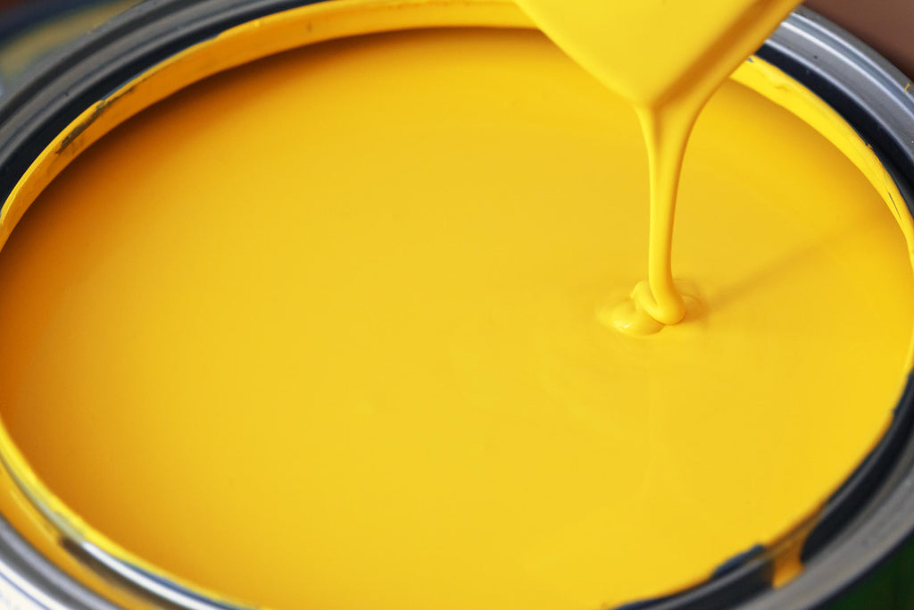 Close up of open yellow paint can